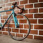 a blue bike leaning on the wall